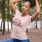 Woman wearing a pink t-shirt with a logo in a forest setting