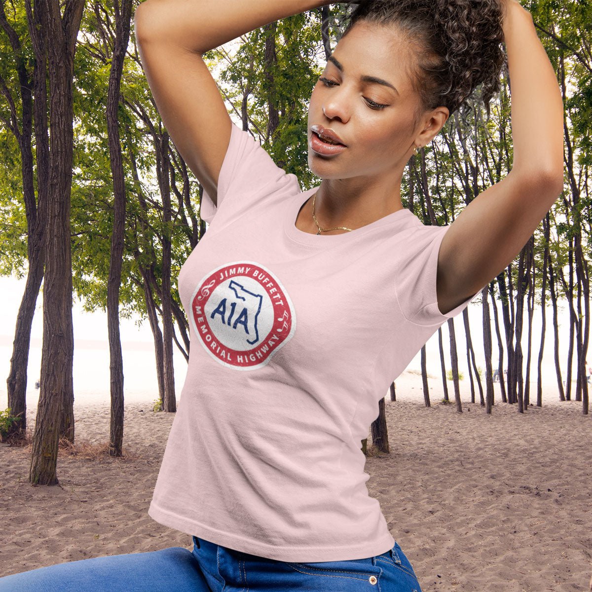 Woman wearing a pink t-shirt with a logo in a forest setting