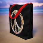 Black Tote Bag with Red Straps featuring a Peace Sign created entirely out of seashells sitting in the sand of your favorite shelling beach