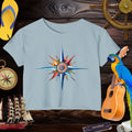 Light blue t-shirt with a colorful compass design on a wooden background with nautical items.