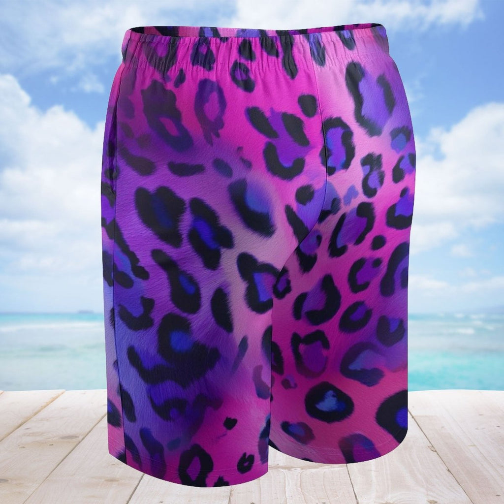 Purple and pink leopard print shorts on a wooden deck with a beach background
