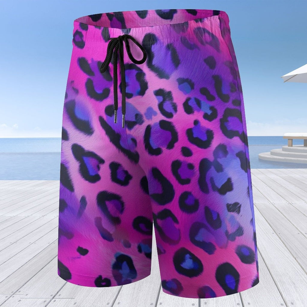 Pink and purple leopard print shorts on a wooden deck with a beach background
