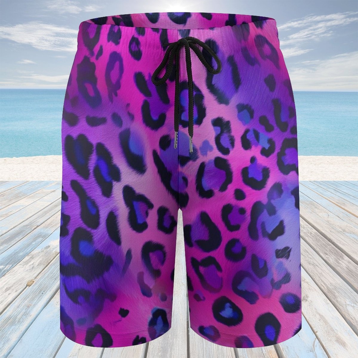 Purple and pink leopard print shorts on a wooden deck with a beach background