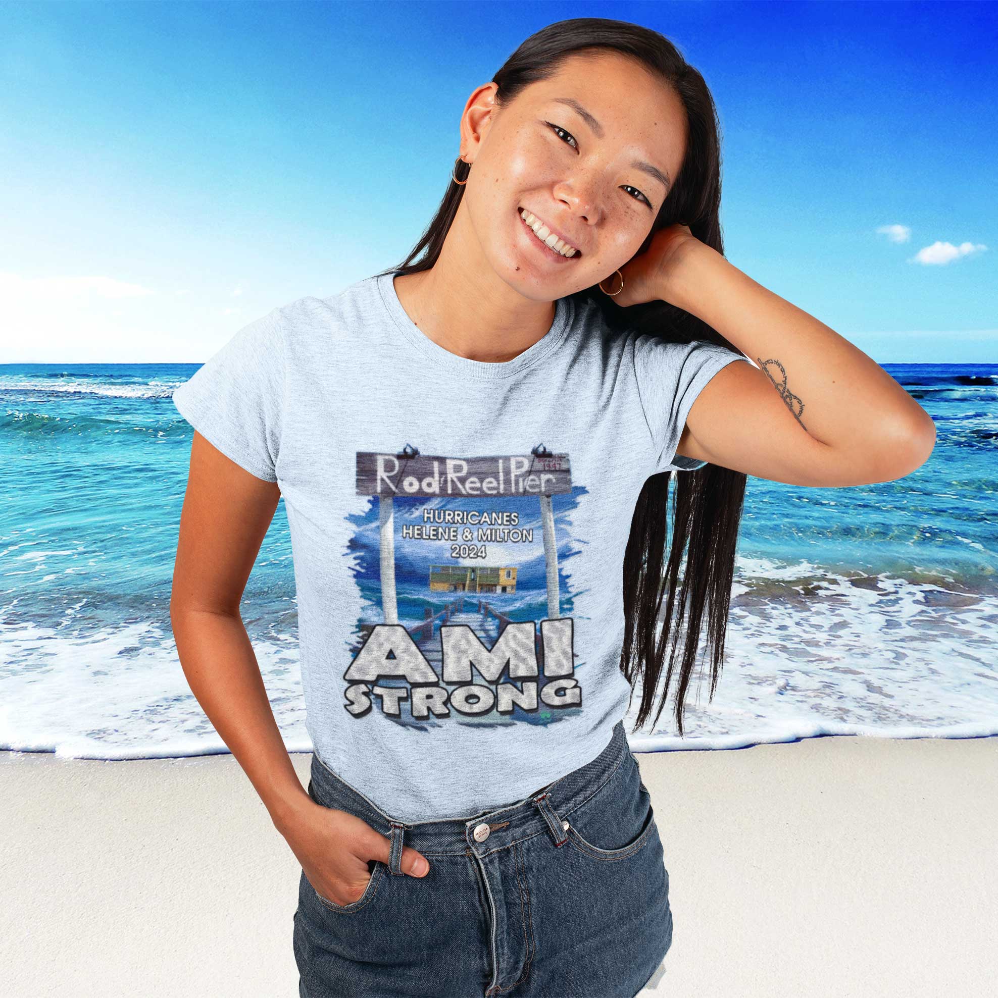 Person wearing a 'AMI STRONG' t-shirt with a beach background