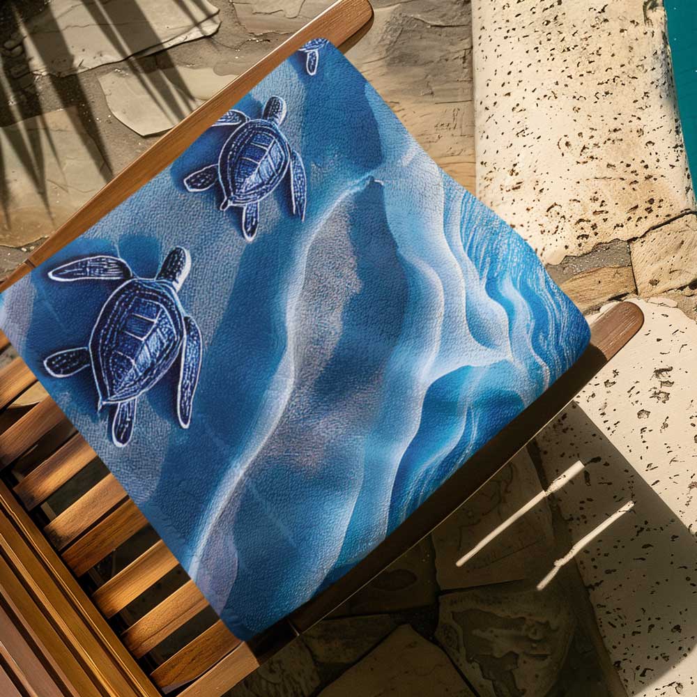 Baby Sea Turtle beach towel folded up on a wooden deck chair next to the swimming pool