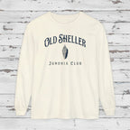 White long-sleeve shirt with 'Old Sheller Junonia Club' text and logo on a wooden background