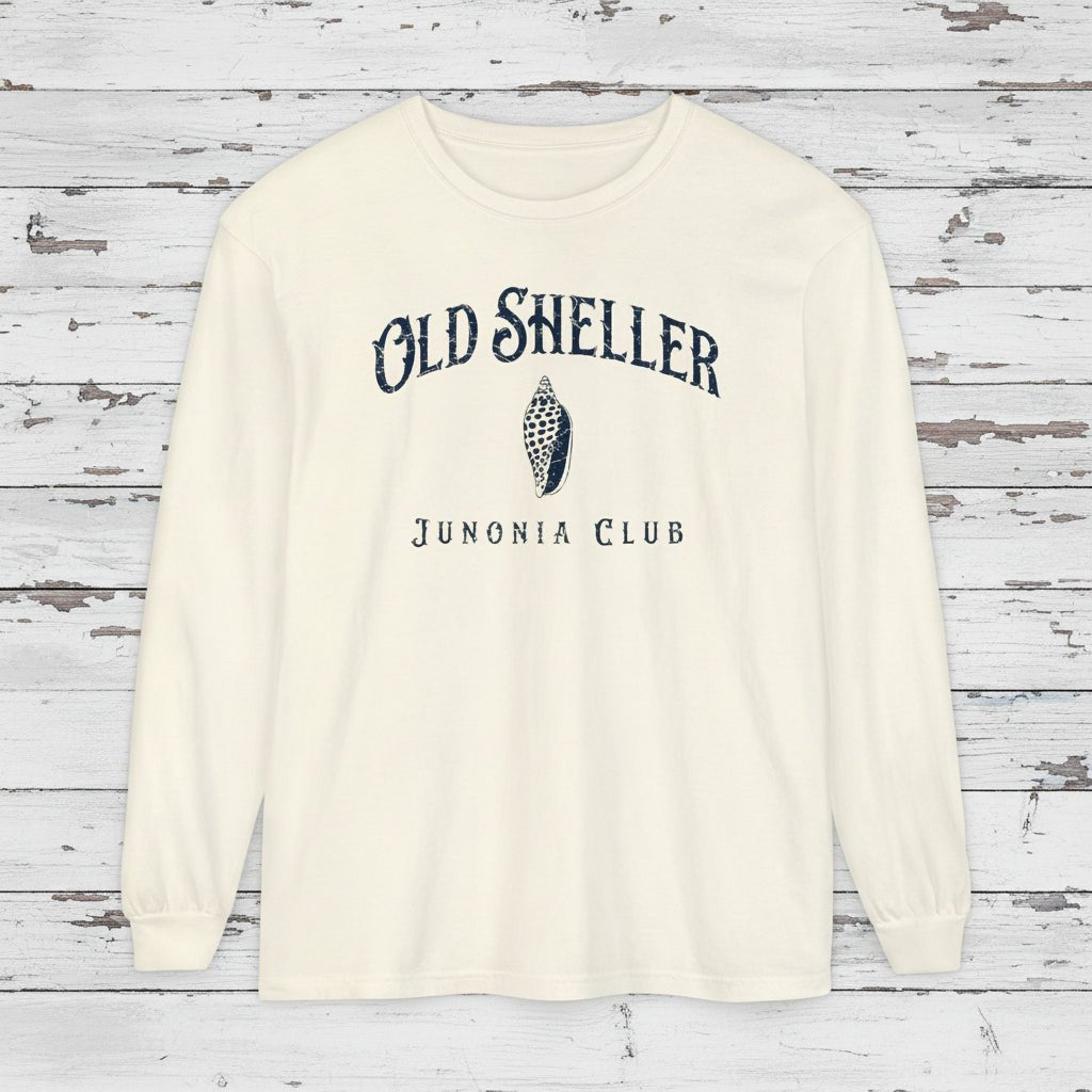 White long-sleeve shirt with 'Old Sheller Junonia Club' text and logo on a wooden background
