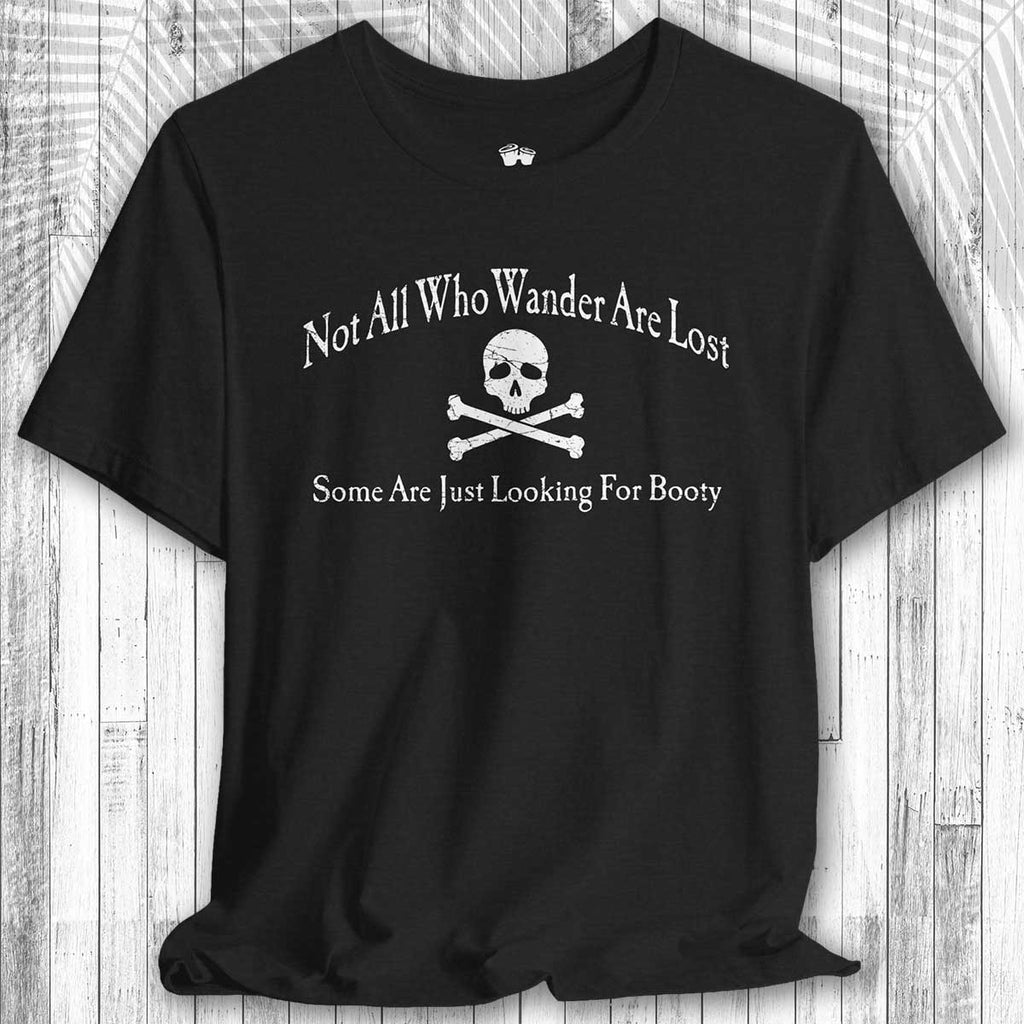 Black pirate adventure graphic tee design and text on a wooden surface