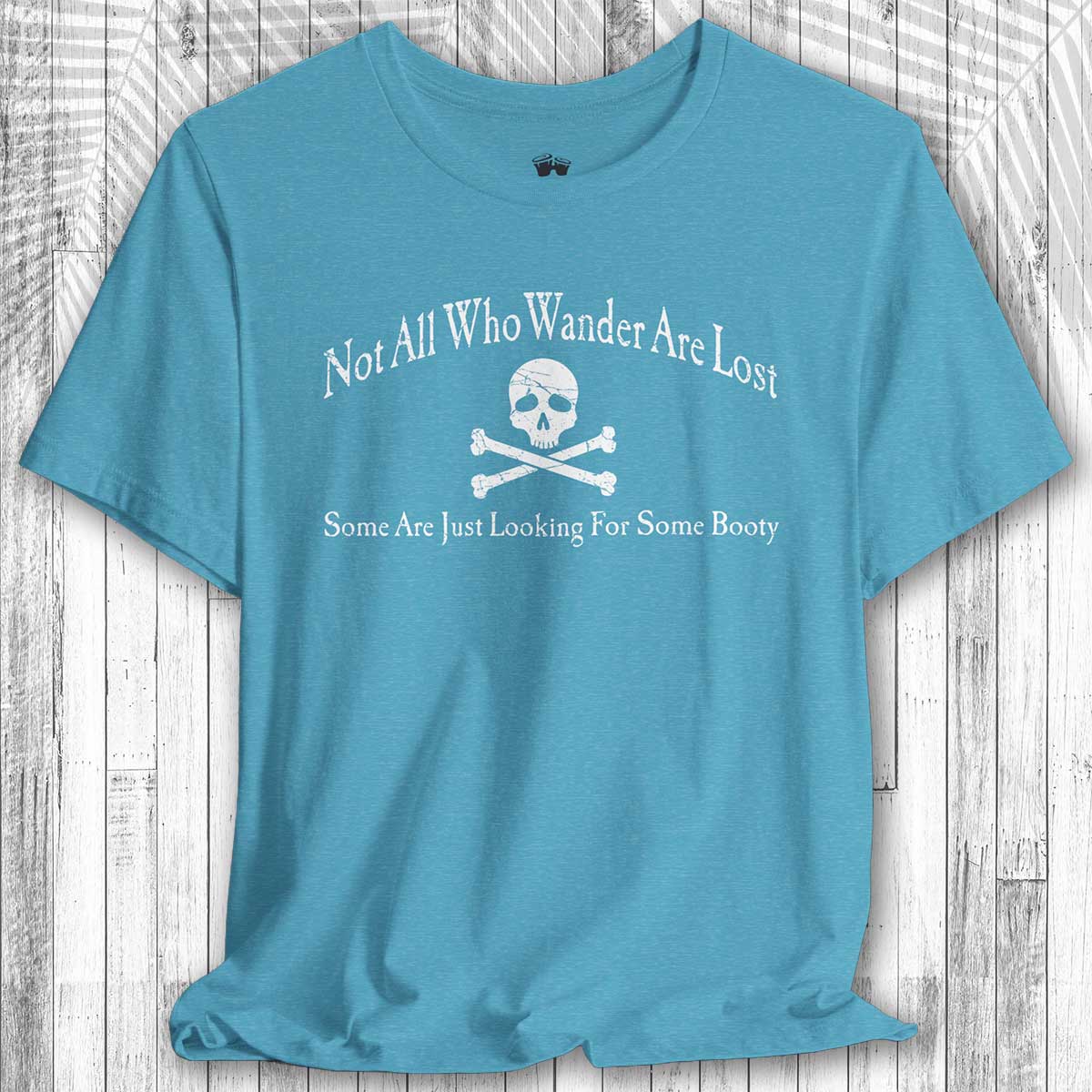 Blue t-shirt with skull and crossbones design and text on a wooden surface