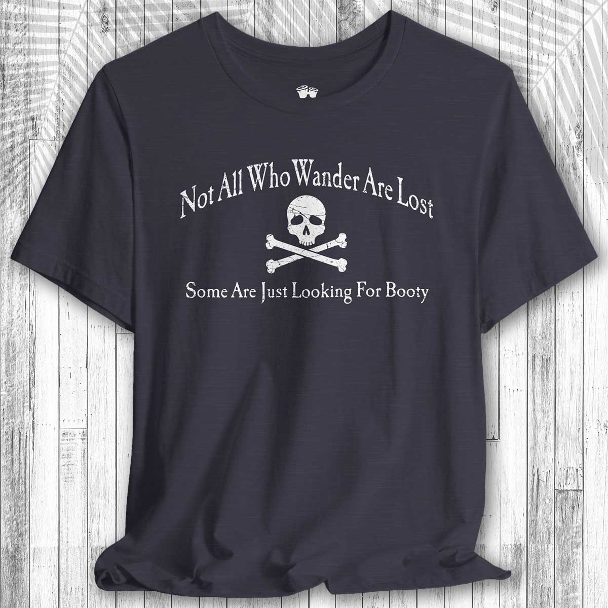 Navy blue t-shirt with skull and crossbones design and text on a wooden surface