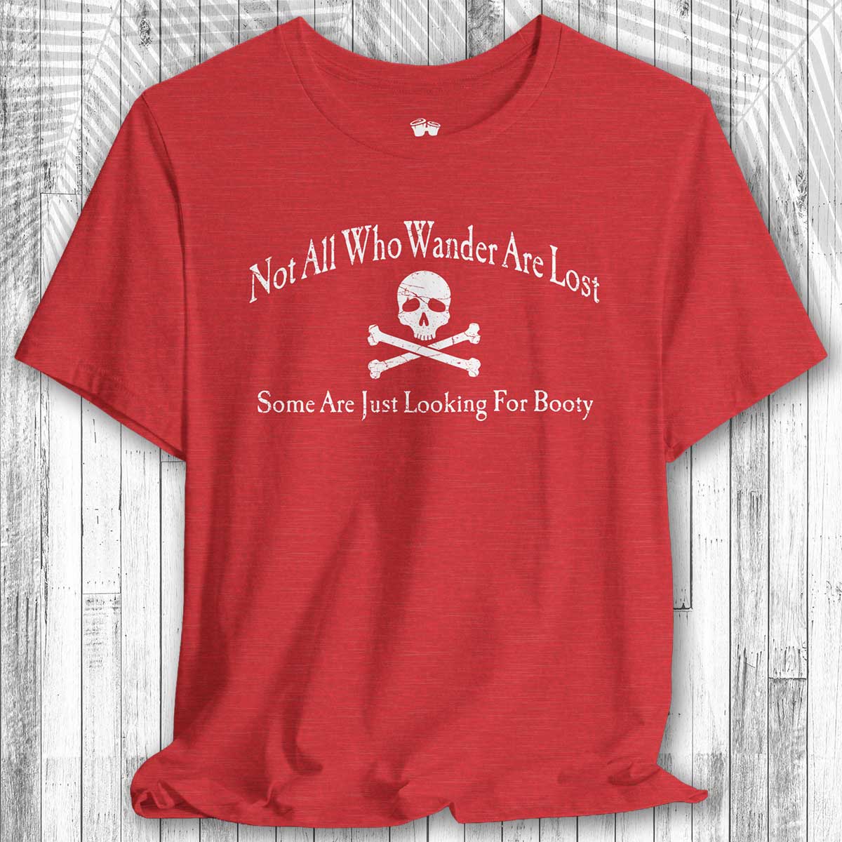 Red pirate adventure graphic tee and text on a wooden surface