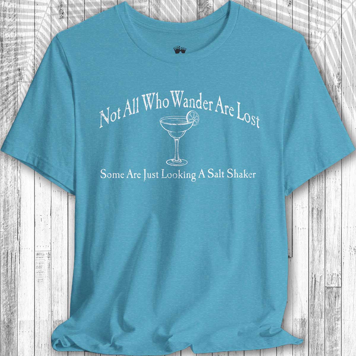 Blue Parrot Head Adventure Shirt  with humorous text and cocktail graphic on a wooden surface