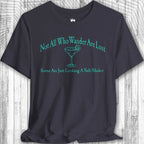 Navy blue Parrot Head Adventure Shirt with green text and a martini glass graphic on a wooden surface