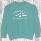 Teal shaka inspired sweatshirt with white text and graphic on a wooden surface