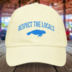 Pastel yellow Manatee hat embroidered with "Respect The Locals" and a manatee silhouette 
