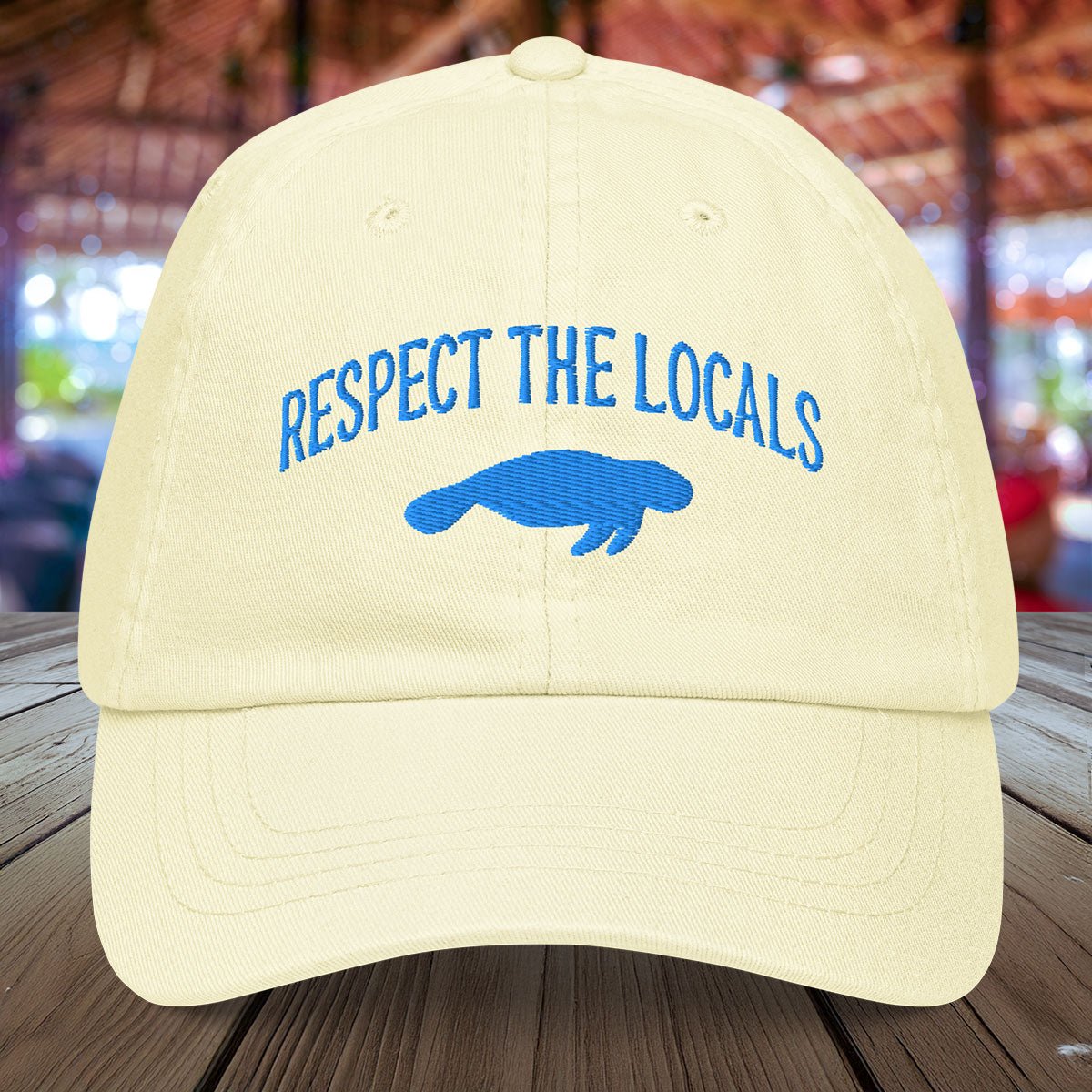 Pastel yellow Manatee hat embroidered with "Respect The Locals" and a manatee silhouette 
