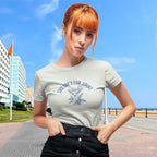 Woman wearing a t-shirt with text and graphic design outdoors on a sunny day.