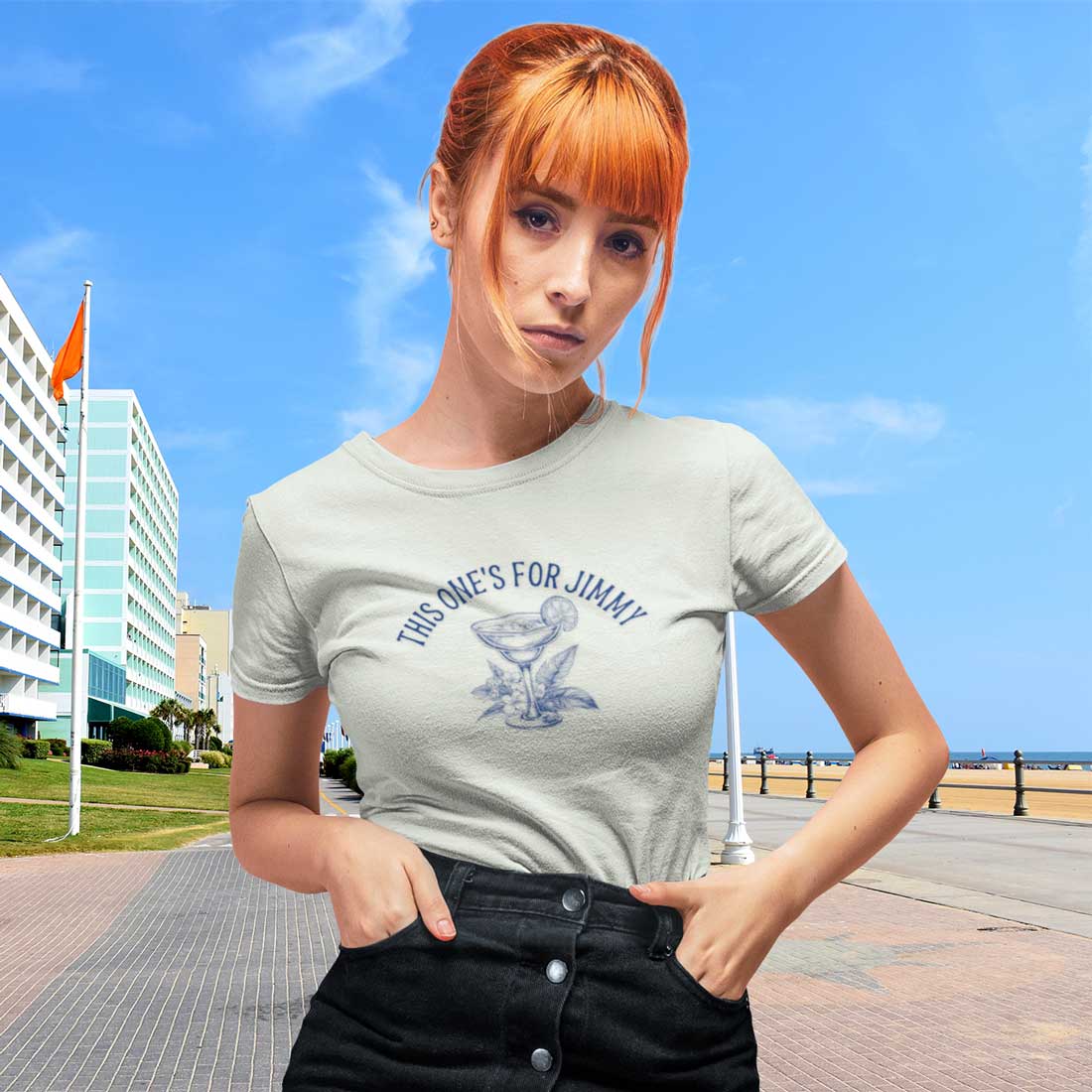 Woman wearing a t-shirt with text and graphic design outdoors on a sunny day.