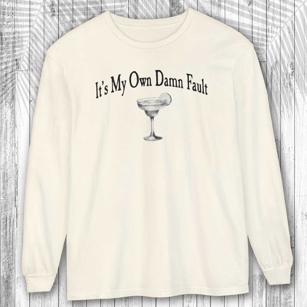 long-sleeve Ivory shirt with a graphic and text It's My Own Damn Fault on a wooden surface