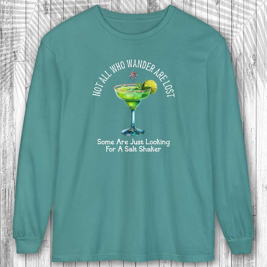 Teal long-sleeve shirt with a graphic of a margarita and text: Not All Who Wander Are Lost - on a wooden background