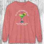Coral long-sleeve shirt with a graphic Not All Who Wander Are Lost t on a wooden surface