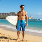 Dude wearing blue striped board shorts holding a surfboard on Waikiki beach
