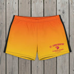 Orange and yellow swim shorts with 'St. Somewhere' branding on a beach.