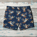 Navy swim shorts with pelican pattern on nautical wood background
