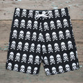 black shorts with white skull and crossbones pattern on a rustic wood background