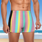 Dude wearing colorful striped swim shorts with a beach background