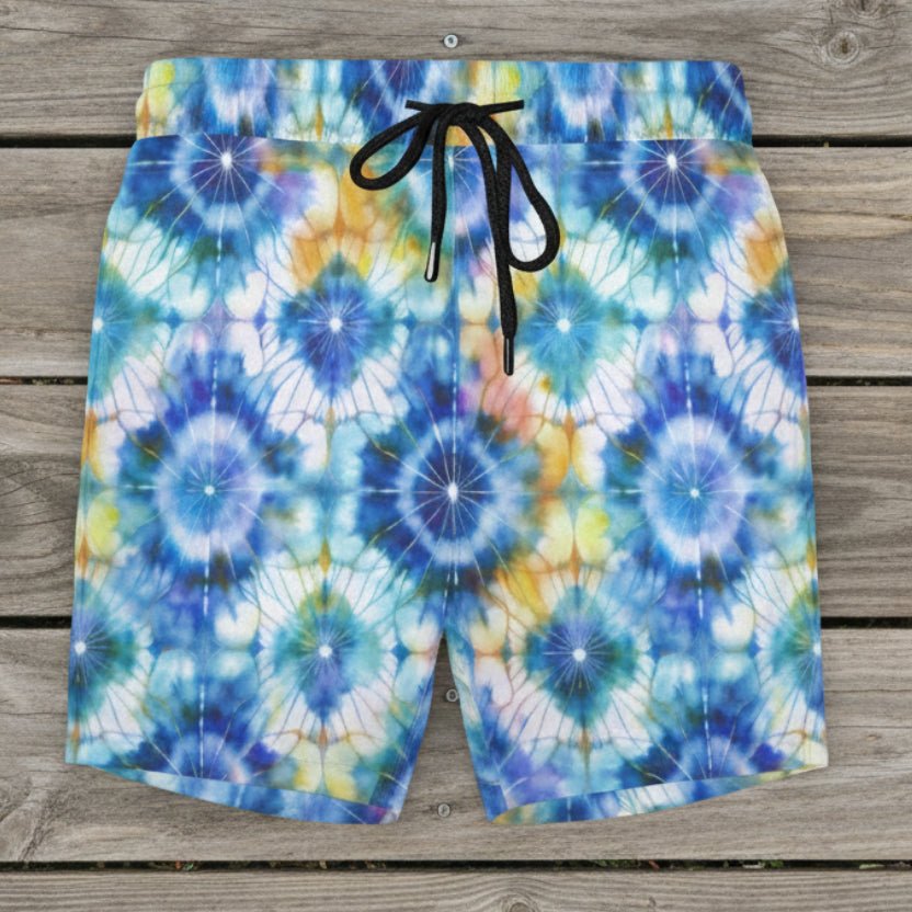 Tie-dye patterned shorts with a drawstring on a rustic nautical wood deck