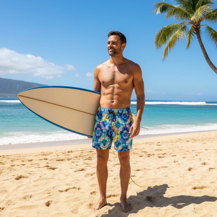 dude wearing Tie-dye swim shorts with a drawstring holding a surfboard next to a palm tree on a Hawaiian beach