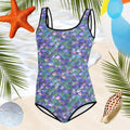 Youth Girl's Mermaid Swimsuit over a beach backdrop with seashells and a beach ball