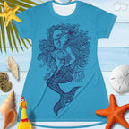 T-Shirt Dress featuring a zentangle mermaid design hand drawn by RonBongo and printed on both sides of the dress. laying on a rustic wood deck surrounded by seashells and and sand dollars and starfish