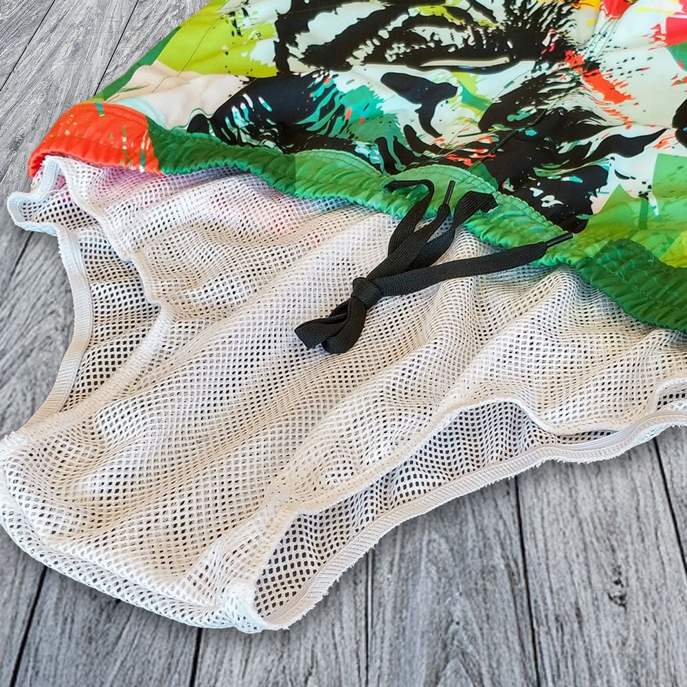 Colorful fish-themed fabric on a wooden surface with a mesh bag.