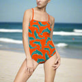 Model in Dolphins Orange One Piece with Teal and White Dolphin Pattern standing in the ocean on beach day