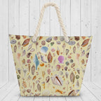 Beach bag with shell pattern and rope handle on a white rustic wood background