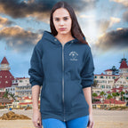 Woman wearing a blue ParrotHead Hoodie with a logo against a beach resort background