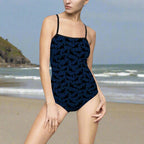 Model standing on the beach wearing a Navy one piece swimsuite with sutle shark pattern print