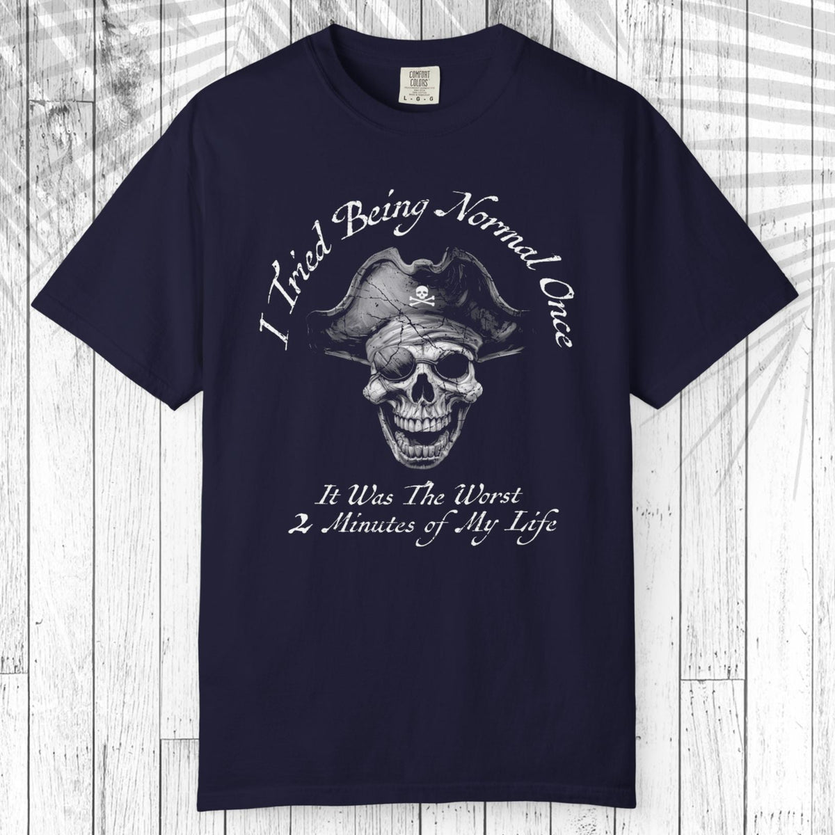 A navy blue short-sleeve t-shirt with a colorful graphic of an open shark mouth on the chest, displayed flat against a white wood plank background.