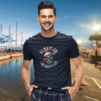 Man wearing a navy blue t-shirt with a graphic design by a marina.