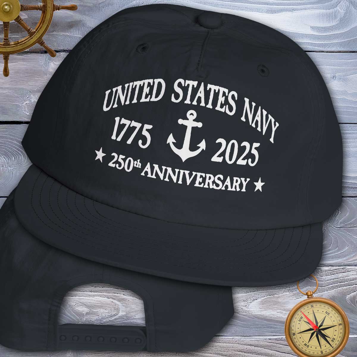 Black cap with 'United States Navy 1775-2025 250th Anniversary' text on a wooden background.