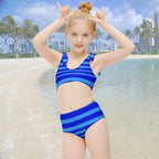 Young girl wearing a blue striped swimsuit on a Hawaiian Island Beach