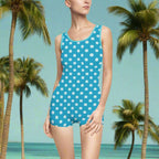 Model wearing vintage one-piece bathing suit with sand dollars for polka dots standing in an island paradise looking for shells