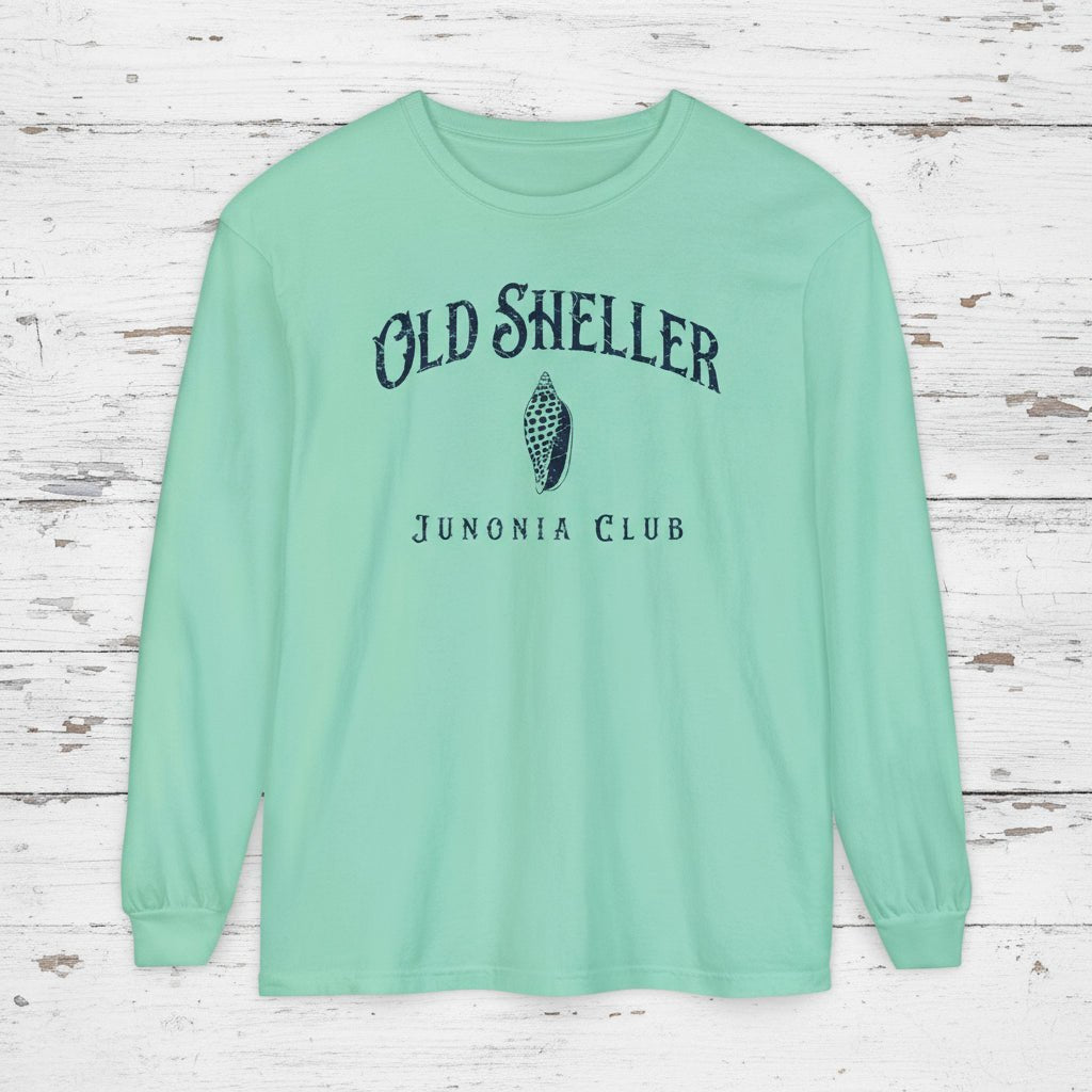 Mint green long-sleeve shirt with 'Old Sheller Junonia Club' text and logo on a wooden surface.