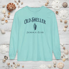Light blue long-sleeve shirt with 'Old Sheller Junonia Club' text and shell graphic on a white background