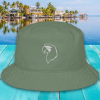 Green bucket hat with a white parrot design on a turquoise wooden surface with a tropical background.