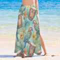 Person wearing a colorful tropical sarong wrap with parrots and drums on a beach.