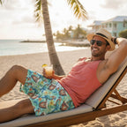 Dude wearing Colorful swim shorts with parrot and drum pattern, sunglasses and a coral colored tank top hanging out in Key West.