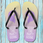 Pair of ParrotHead Flip-Flops with purple soles and black straps on a wooden surface.